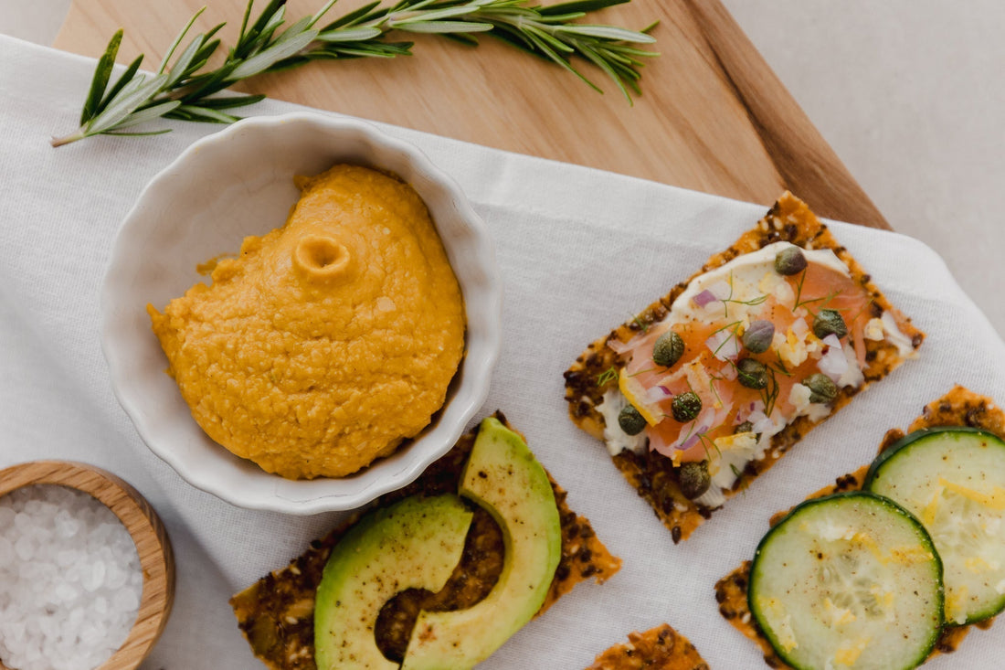 Pumpkin hummus served in a bowl with crackers